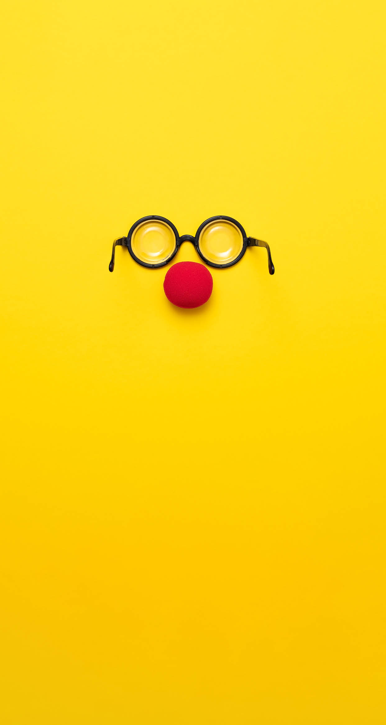 Funny glasses, a red clown nose and tie on a colored background, like a face  Flat lay  Funny costume for the holidays  Anonymous concept 